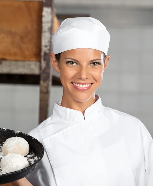 Jeune femme tenant des boules de pâte dans le plateau de cuisson — Photo