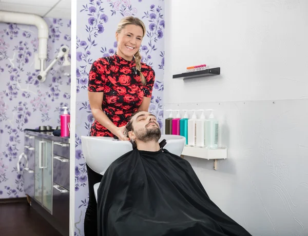 Säker kosmetolog tvätt manliga kunder hår — Stockfoto