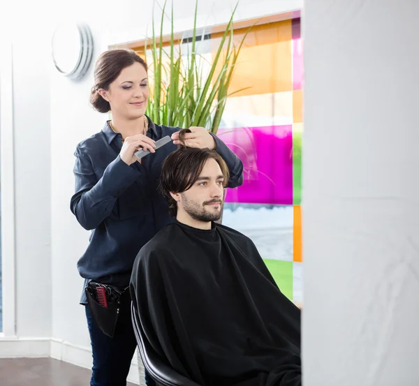 Coiffeur coupe les cheveux des clients dans le salon — Photo