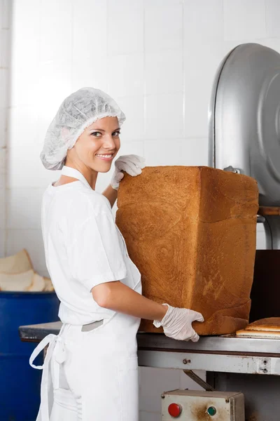 Αυτοπεποίθηση Baker με ψωμί φραντζόλα στέκεται στο τραπέζι — Φωτογραφία Αρχείου