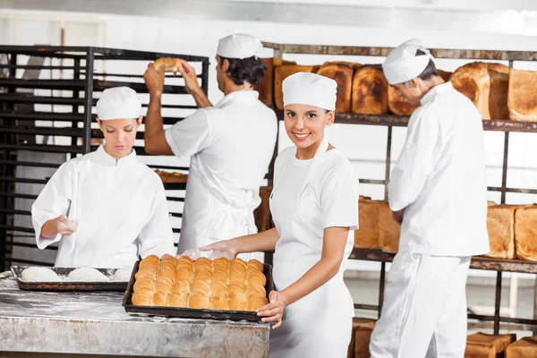 Уверенный пекарь показывает хлеб в пекарне — стоковое фото