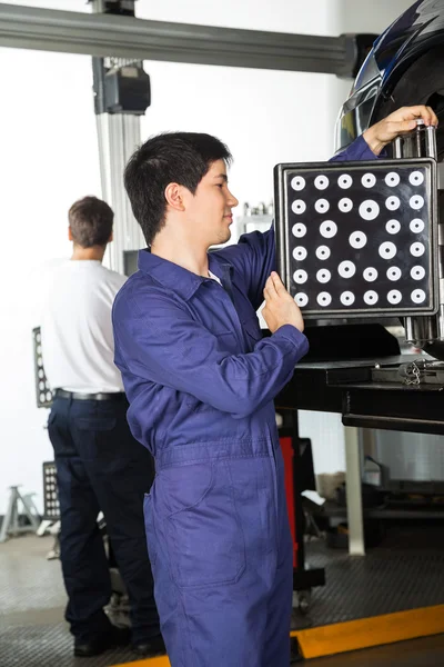 Meccanico utilizzando Wheel Aligner su auto in garage — Foto Stock