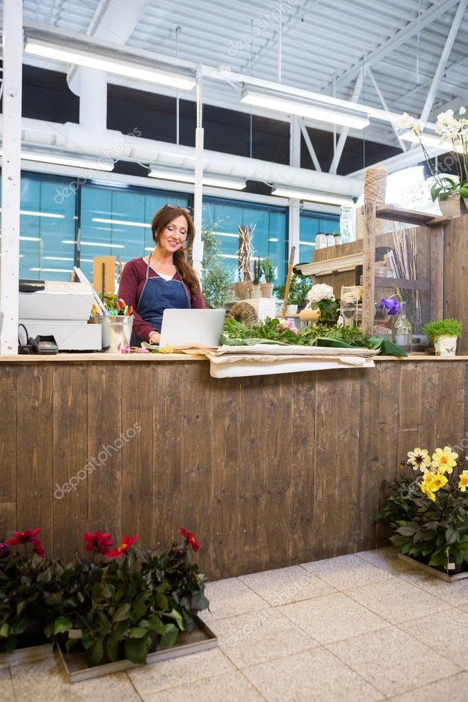 Florist Using Laptop At Counter In Flower Shop — Stock Photo