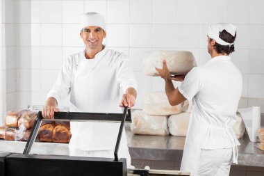 Male Baker Using Vacuum Seal Machine In Bakery clipart