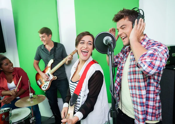 Cantores excitados realizando enquanto colegas tocando música Inst — Fotografia de Stock