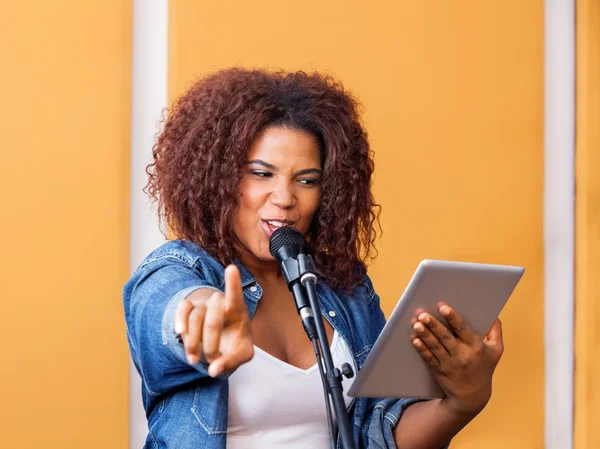 Cantante femenina señalando mientras sostiene la tableta digital —  Fotos de Stock