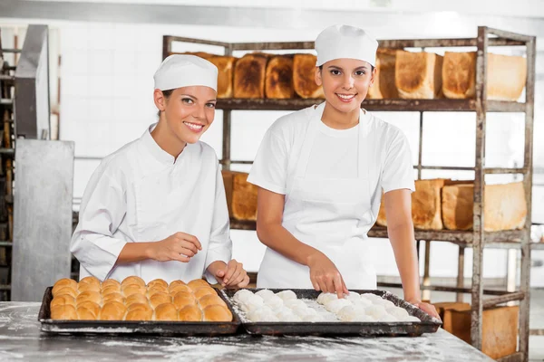 Panaderos femeninos confiados analizando la masa en la mesa — Foto de Stock