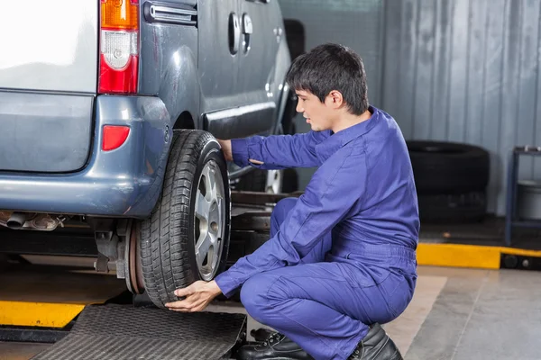 Monteur ter vervanging van de auto banden op reparatiewerkplaats — Stockfoto