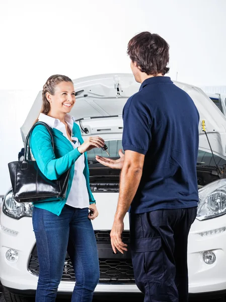 Cliente feliz dando llaves del coche a mecánico —  Fotos de Stock