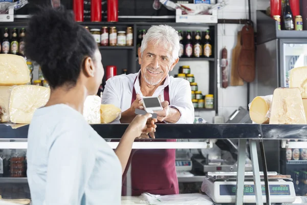 Verkoper u een betaling van de klant In de kaaswinkel accepteert — Stockfoto