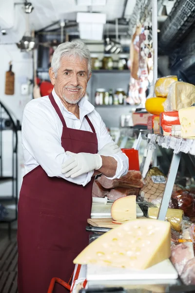 Säker säljare står vid disken i ost butik — Stockfoto