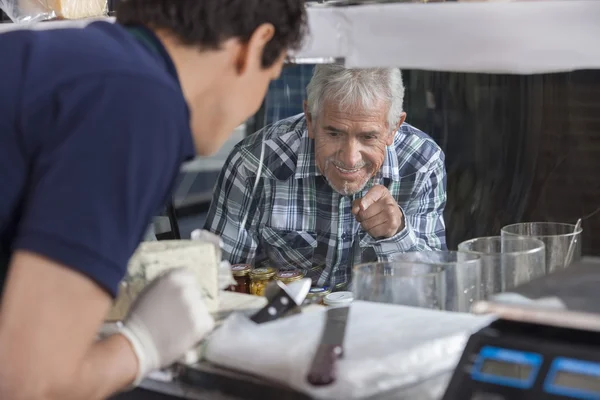 Peynir dükkanı dolapta ekran seçme adam — Stok fotoğraf