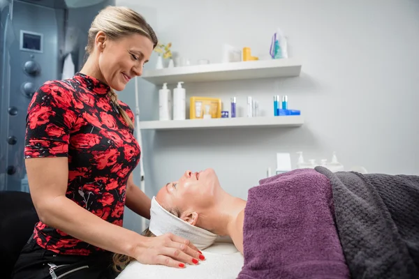 Schoonheidsspecialiste glimlachen terwijl kijken naar klant In Salon — Stockfoto