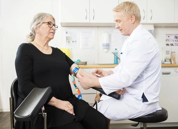 Doctor Collecting Senior Patients Blood For Test In Clinic — Stock Photo, Image