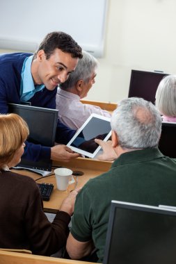 Kıdemli öğrenci dijital Tablet üzerinde öğretmen soru soran
