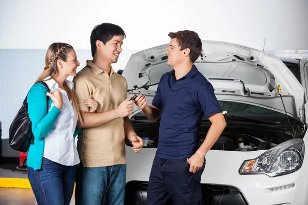 Happy Couple Giving Car Keys To Technician — Stock Photo, Image