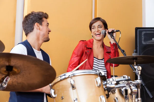 Zangeres uitvoeren tijdens het kijken naar mannelijke Drummer — Stockfoto