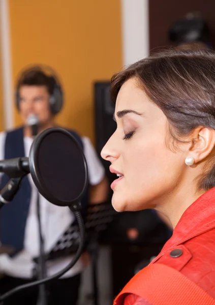 Femme aux yeux fermés chantant en studio — Photo