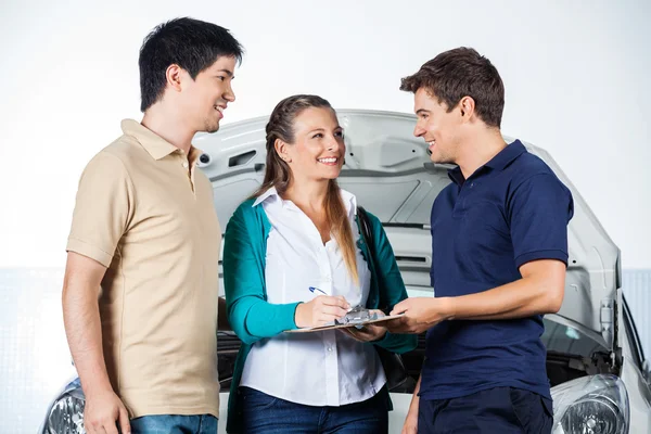 Mechanic Taking Sign From Couple — Stock Photo, Image