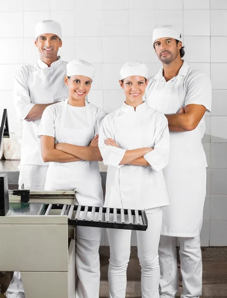 Selbstbewusste Bäcker mit verschränkten Armen in Bäckerei — Stockfoto