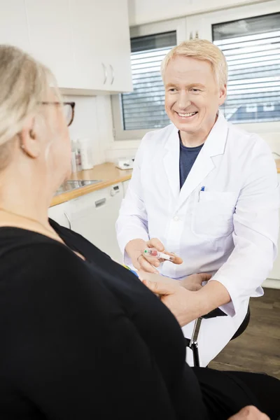 Médecin souriant recueillant le sang des patients âgés pour le test dans — Photo