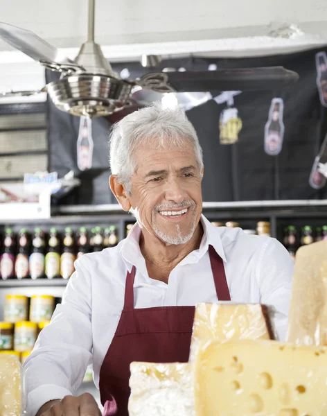 Vendedor feliz na loja de queijo — Fotografia de Stock