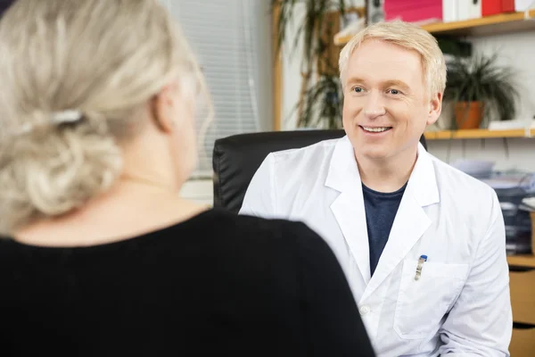 Patrząc na starszy pacjent w gabinecie lekarza — Zdjęcie stockowe