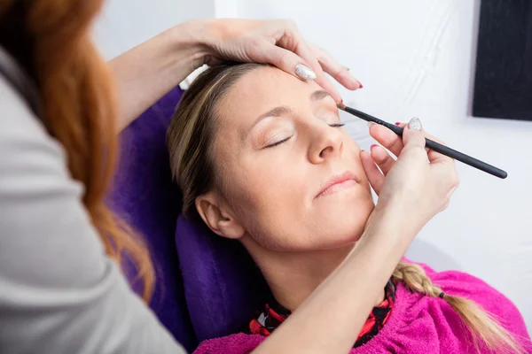 Mulher tendo sua maquiagem aplicada no salão — Fotografia de Stock