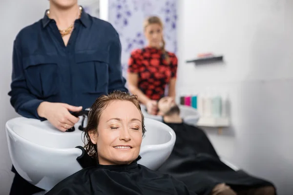 Femme détendue se faire laver les cheveux dans le salon — Photo