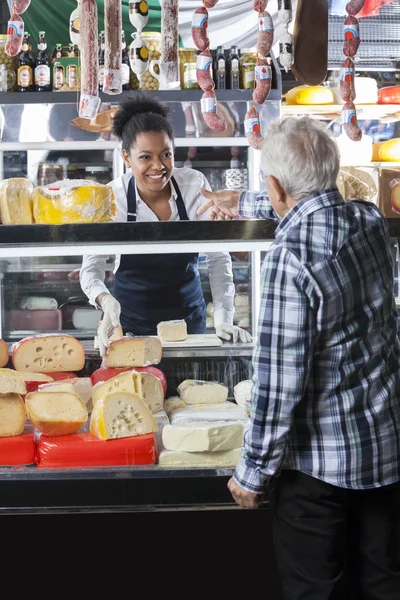 Ekspedientka biorąc zlecenia od klienta w sklepie ser — Zdjęcie stockowe