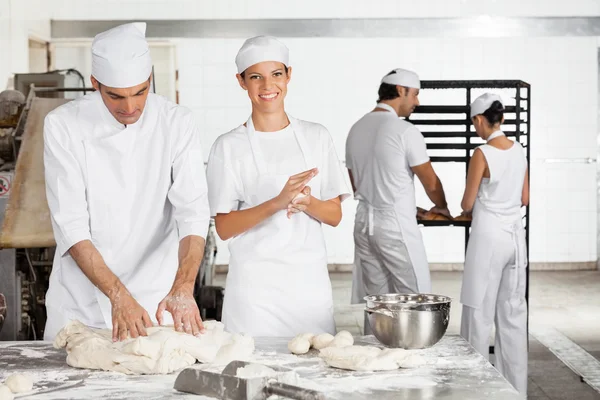 Baker Making Dough Balls By Male Colleague In Bakery — Stock Photo, Image