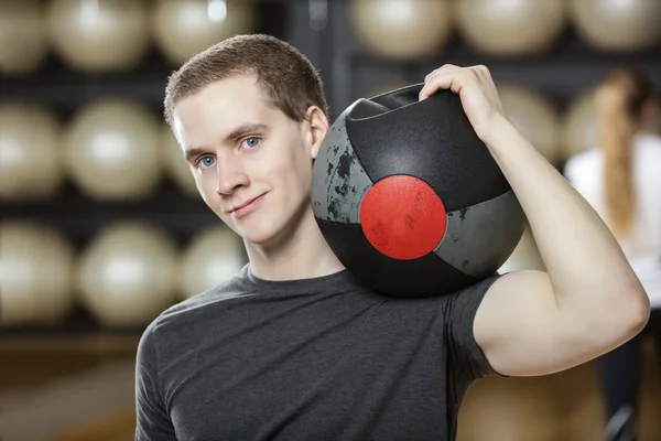 Man hålla medicin boll på axeln i Gymnasium — Stockfoto