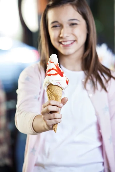 Chica mostrando sabroso helado con jarabe de fresa — Foto de Stock