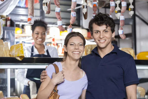 Портрет счастливой молодой пары в сырном магазине — стоковое фото