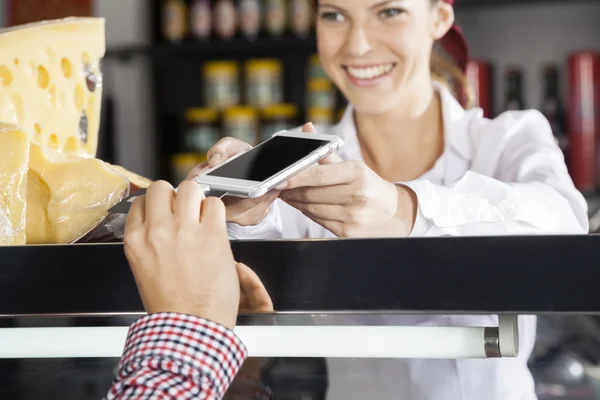 Prodavačka přijímat platby od zákazníků prostřednictvím kreditní karty — Stock fotografie