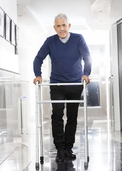 Homem sênior usando Walker no centro de reabilitação — Fotografia de Stock