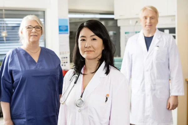 Profesional médico femenino de pie con el equipo — Foto de Stock