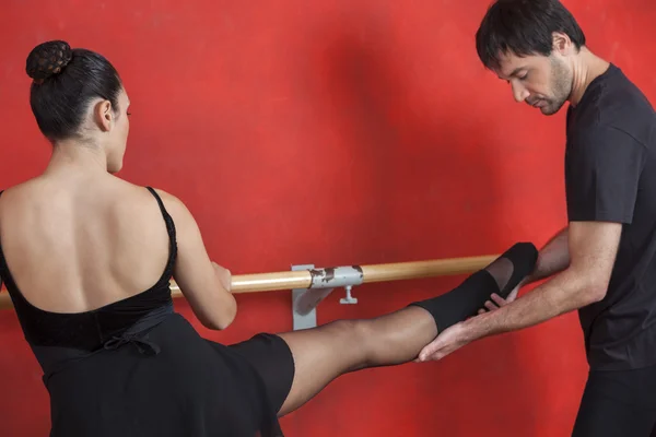 Trainer Assisting Female Ballet Dancer At Barre In Studio — Stock Photo, Image