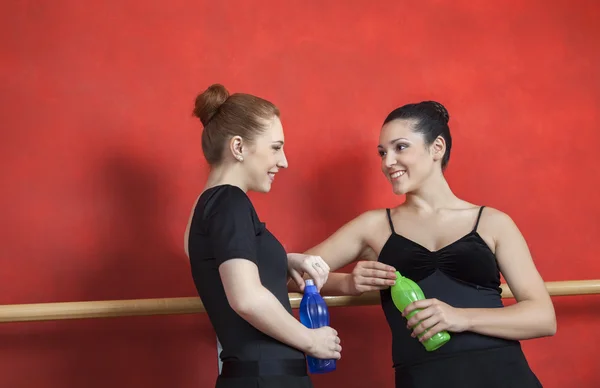 Amigos sosteniendo botellas de agua en el estudio de ballet —  Fotos de Stock