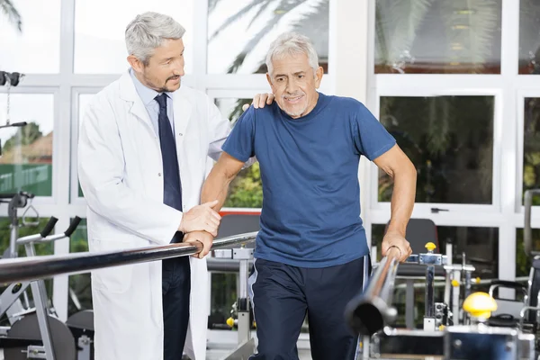 Doutor Motivando o homem sênior para andar no estúdio de fitness — Fotografia de Stock