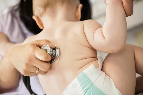 Педиатры осматривают ребенка руками, хотя и стетоскоп — стоковое фото