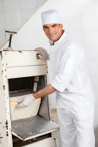 Αρσενικό Baker χρησιμοποιώντας ψωμί κόπτης στο αρτοποιείο — Φωτογραφία Αρχείου