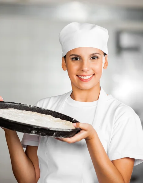 Θηλυκό Baker με ζύμη δίσκο στο αρτοποιείο — Φωτογραφία Αρχείου