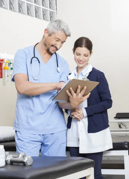 Physiotherapeut zeigt Kollegin im Reha-Zentrum Berichte — Stockfoto