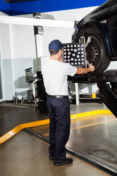 Mekaniker med hjul justering maskin på bil — Stockfoto