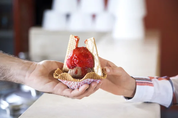 Empregados de mesa dão sorvete com xarope de morango para mulher — Fotografia de Stock