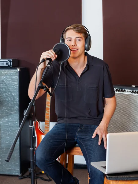 Cantante masculino en casuales que actúa en el estudio de grabación —  Fotos de Stock