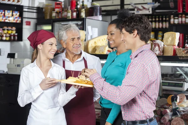 Salespeople Offering Cheese Samples To Customers In Shop — Stock Photo, Image