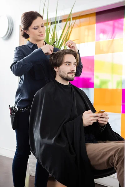 Cliente masculino recebendo corte de cabelo no salão de cabeleireiro — Fotografia de Stock