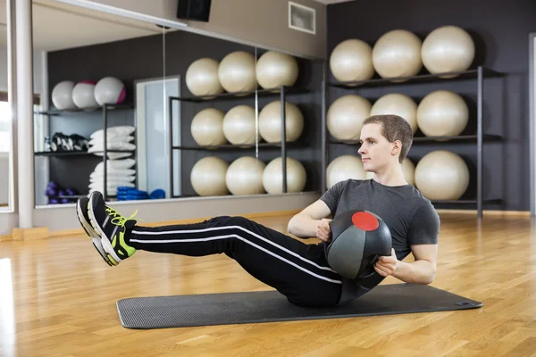 Hombre haciendo ejercicio con balón de medicina en el gimnasio — Foto de Stock